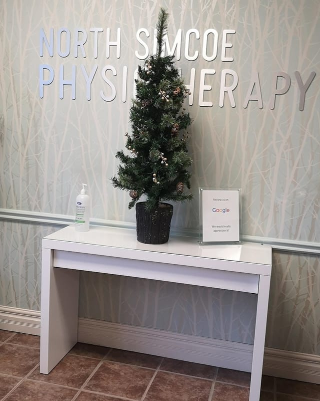 The clinic's entrance wall, with the North Simcoe Physiotherapy sign above a console table
