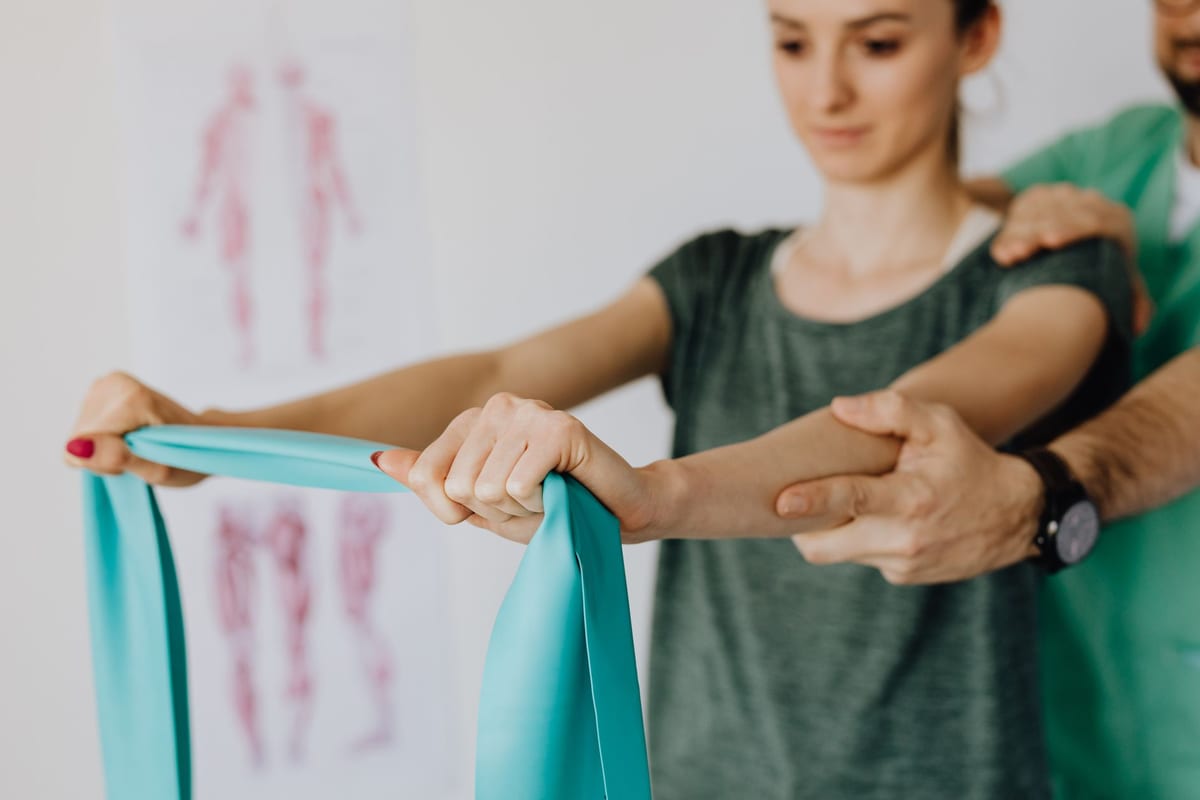 A therapist guiding a patient through a resistance band exercise